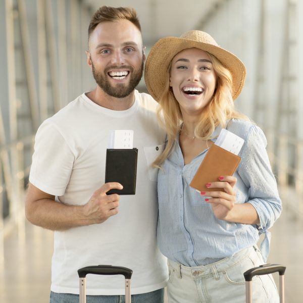 happy-couple-with-passports-and-tickets-at-airport-terminal.jpg